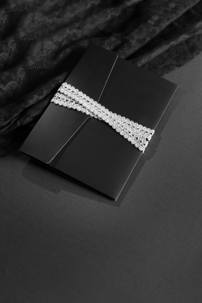 黑色信封模型，从顶部拍摄的黑色背景与复制空间。用银丝带系着。图片下载