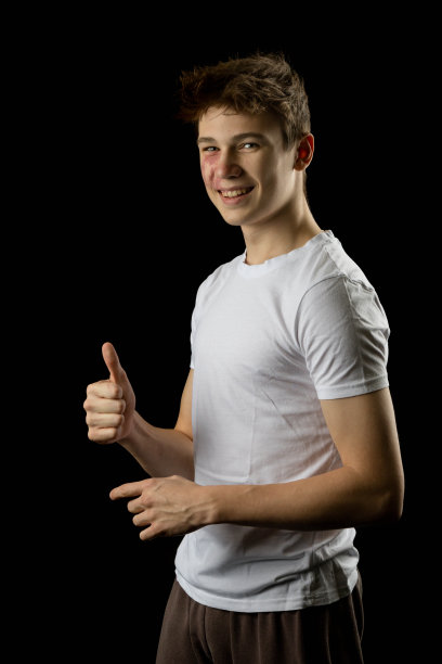 一个17岁男孩的肖像，黑色背景图片下载