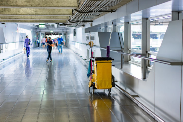 在机场大厅，人群背景模糊的情况下，用暴徒、垃圾箱、抹布、扫把清洁管家的设备。图片下载