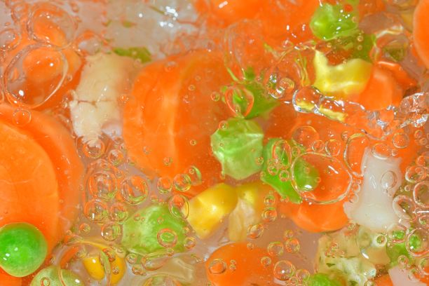 特写新鲜蔬菜汤与胡萝卜，豌豆，花椰菜和玉米在白色背景。白底白水，用胡萝卜、豌豆、花椰菜和玉米煮蔬菜，特写。水平的形象。俯视图，平面设计图片下载