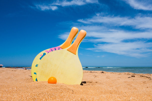 球拍和球在沙滩上对着天空图片下载