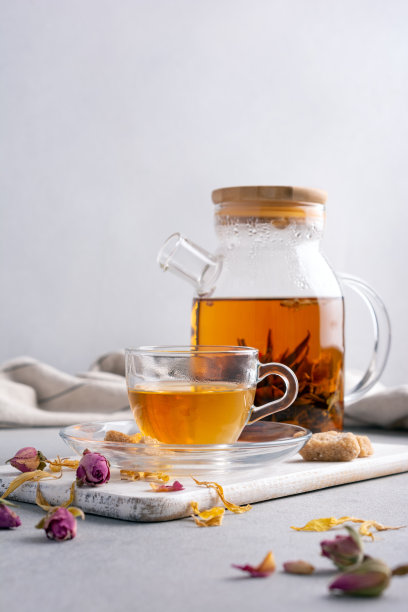 玻璃茶壶热香工艺花茶与杯子和干玫瑰花蕾，糖图片下载