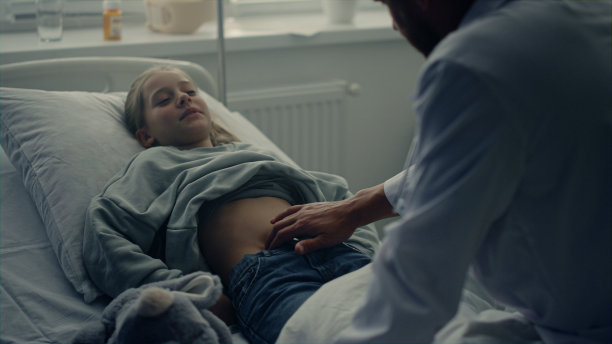 治疗后，内科医生到病人病房。可爱的女孩躺在病床上图片下载