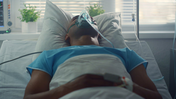 男病人呼吸氧气面罩躺在床上。特写医生双手使用片剂图片下载