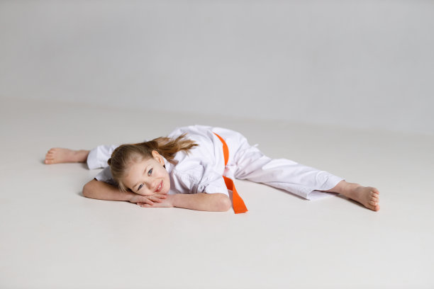 小孩小女孩在空手道上缠绕技巧。图片下载