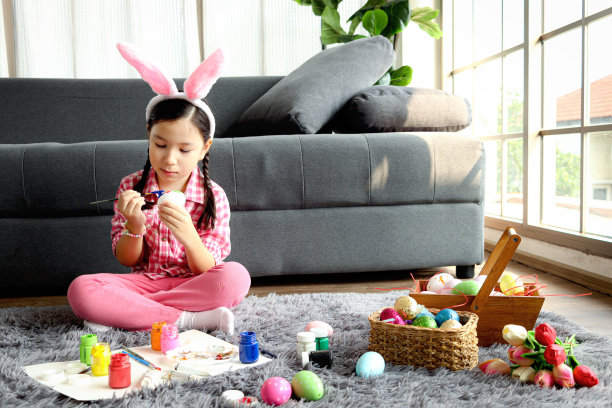快乐可爱的粉色小复活节兔子女孩小朋友带着兔子耳朵的发带，嘻嘻哈哈地找到五颜六色的复活节彩蛋后，玩起了找彩蛋的游戏，庆祝复活节春天的开始。图片下载
