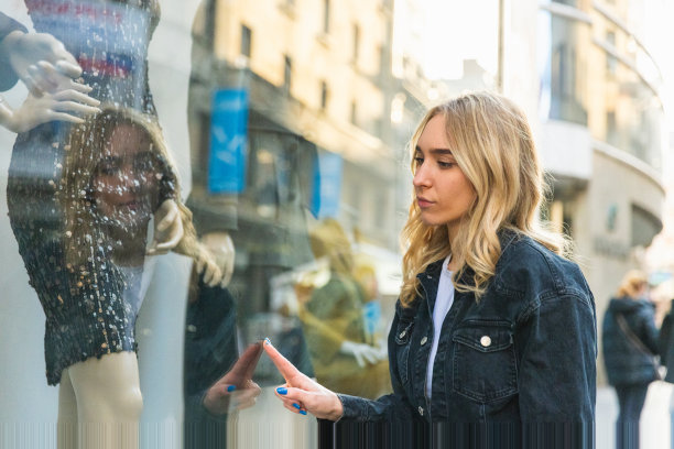 美丽的金发女孩走向相机，同时看着手机购物袋与太阳为背景-中镜头-日光图片下载
