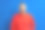 难以置信的震惊的男人在红色套头衫看着相机和保持他的嘴张开，站在灰色背景。图片下载