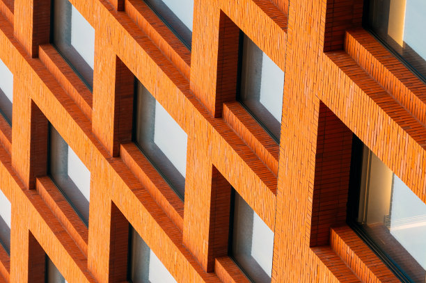 橙色建筑立面上依次排列的窗户特写图片下载