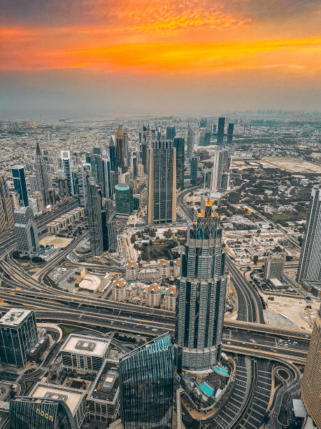 从阿联酋哈利法塔观景台鸟瞰迪拜市中心的道路、迪拜购物中心和日出时的喷泉图片下载