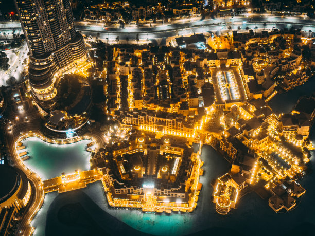 从阿联酋哈利法塔观景台俯瞰迪拜市区的道路、迪拜购物中心和夜间喷泉图片下载