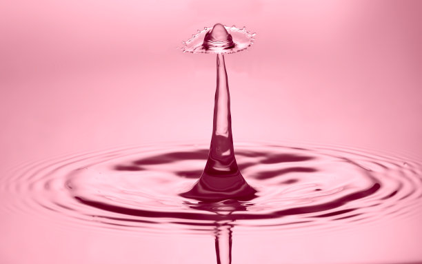 水滴在玫瑰色的灯光效果背景。图片下载