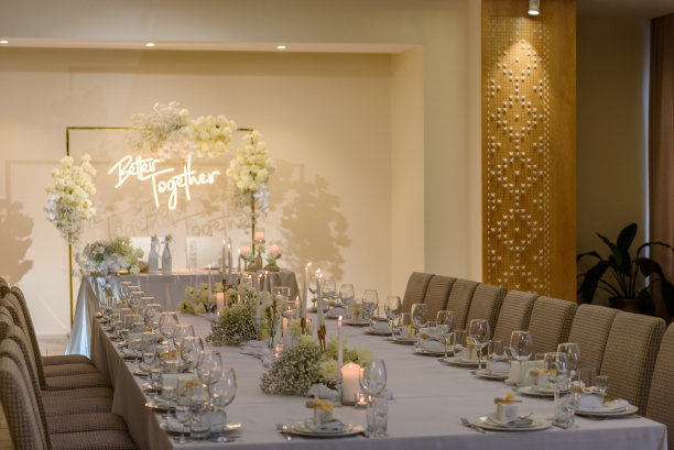 表设置。婚宴装饰大厅餐厅。婚礼的设置。豪华的婚宴。喜庆的拱门装饰着鲜花和蜡烛。聚会区桌子上铺着台布。图片下载