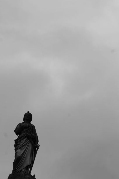垂直拍摄的雕像，背景是阴郁的天空图片下载