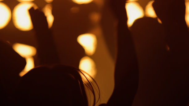 歌迷们在夜总会欣赏音乐会。激动的观众举手图片下载