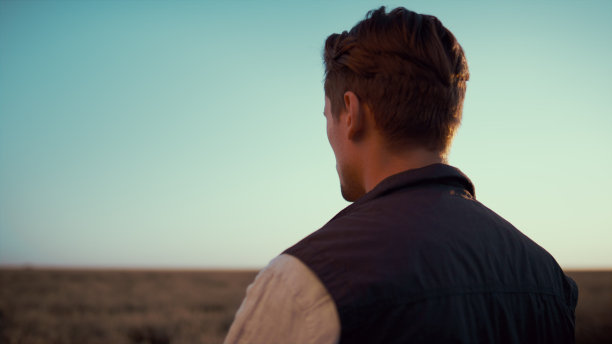 农民用智能手机拍摄田地照片，金色的秋日阳光后视图。图片下载