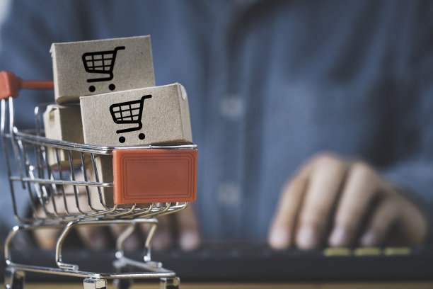 小纸箱盒内购物车与购物者输入订单，使用电脑笔记本电脑进行网上购物和电子商务的经营理念。图片下载