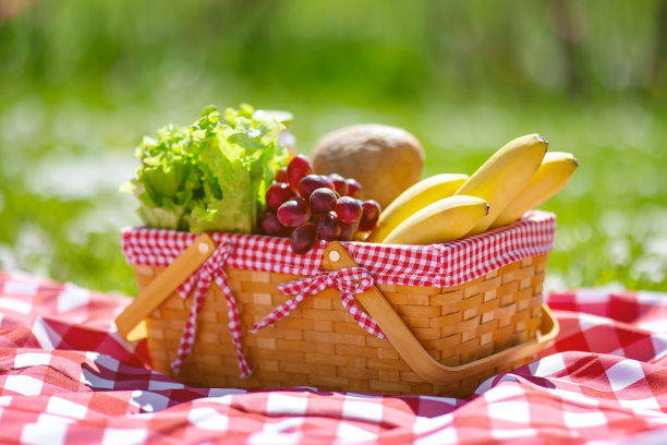 在大自然的野餐毯上，放着食物的柳条篮子。图片下载