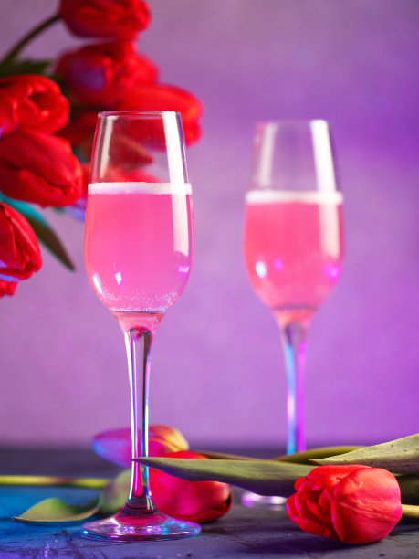 两杯粉色香槟或葡萄酒，一束红色郁金香。霓虹灯。妇女节贺卡图片下载