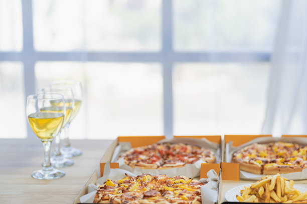 一群吃意大利披萨的员工在午餐或晚餐店手工挑选披萨。美味的海鲜肉汁酱。传统的意大利快餐在木桌上喝葡萄酒。图片下载