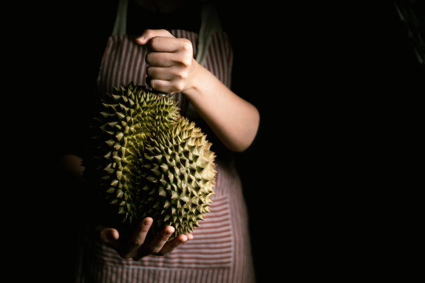 农民手握成熟的榴莲，热带水果之王。图片下载
