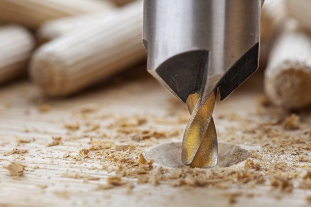 沉孔钻头用钢三角尺在橡木木板上钻螺丝孔图片下载