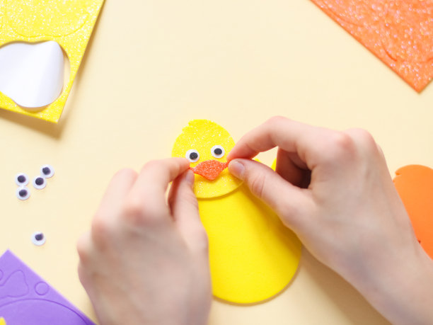 一个白人少女坐在桌子旁，用手指贴着一个橙色的鸟喙贴纸图片下载