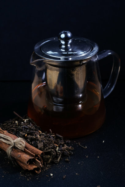 热腾腾的凉茶放在茶壶里，用古老的构图放在桌上图片下载