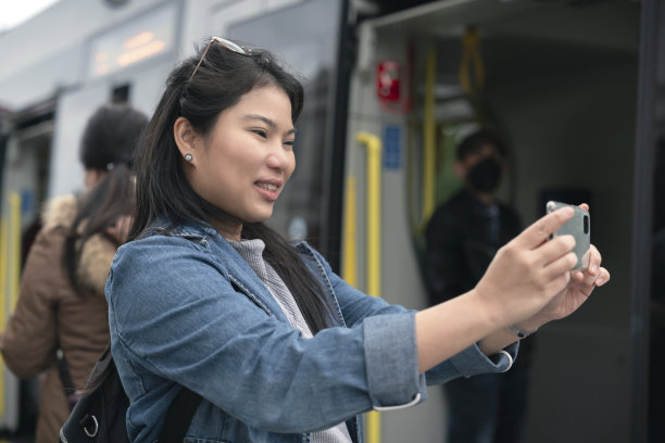 亚洲女性旅行者享受假期度假城市散步手使用智能手机拍摄维也纳市政厅在奥地利维也纳历史名城中心之旅图片下载