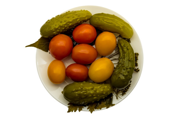 腌制的西红柿和黄瓜放在盘子里，白色背景隔离开来图片下载