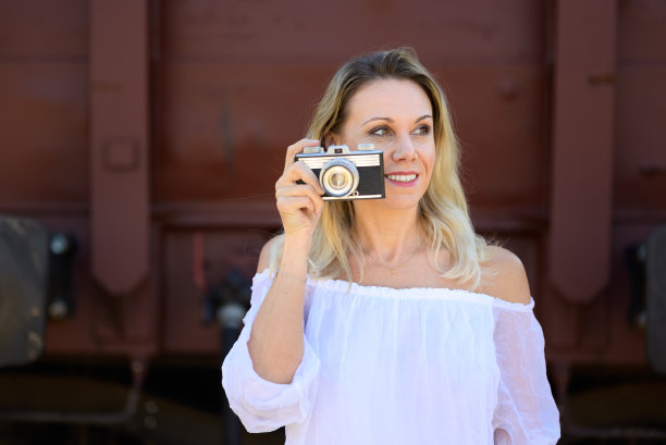 微笑的女人用旧相机拍照图片下载