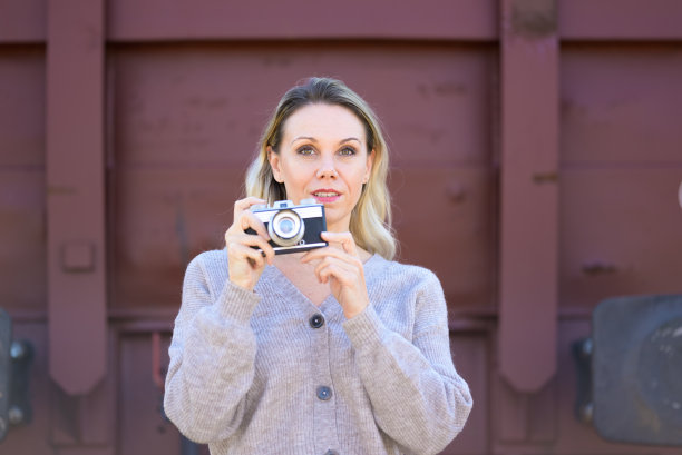 中年妇女拿着一个旧相机图片下载