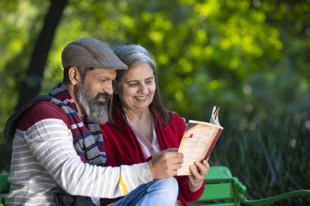 印度老人和女人在公园读书。图片下载
