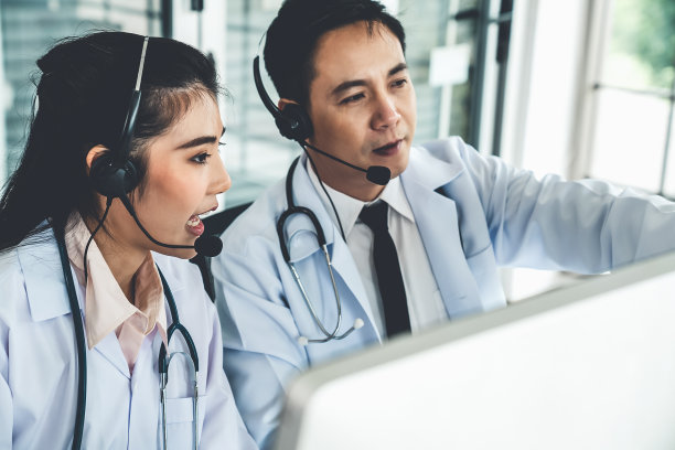 医生团队戴着耳机在医院诊所进行视频通话。远程保健和远程医疗服务的概念。图片下载
