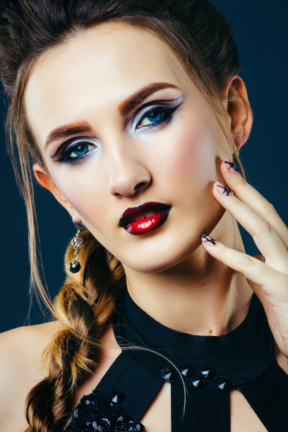 一个白人女孩穿着一件裁剪条纹的裙子，在黑暗的背景下做模特图片下载