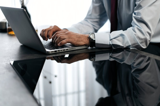 高级男子检查工作在厨房的笔记本电脑在家里图片下载