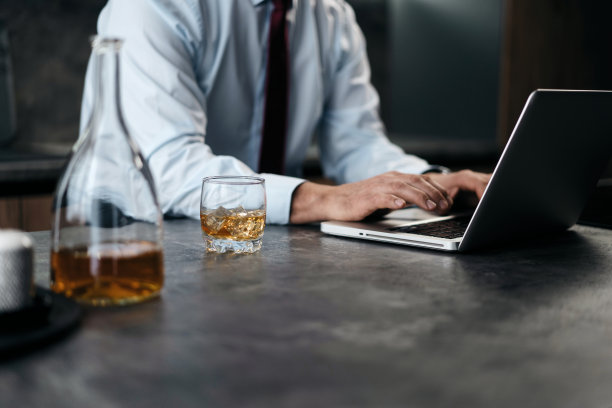 高级男子检查工作在厨房的笔记本电脑在家里图片下载