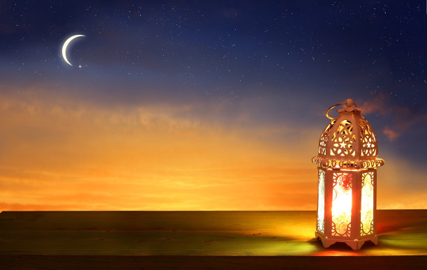 穆斯林节日的开斋节卡片。庆祝古尔邦节。木桌上的阿拉伯斋月灯笼。装饰台灯。新月和星星。图片下载
