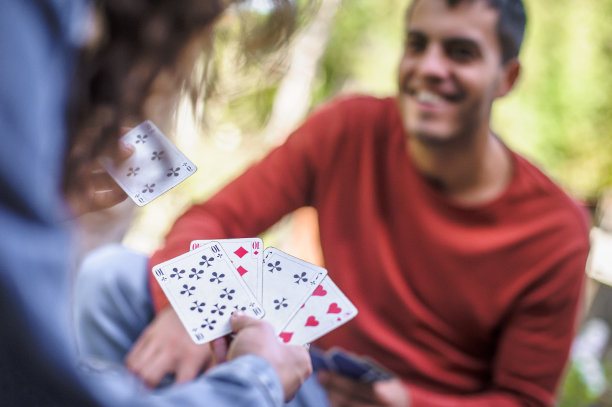 一对情侣在春天的花园里一起放松和打牌，特写图片下载