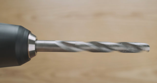 旋转钻，特写，在木制桌面的背景上。演示用电动螺丝刀钻金属图片下载