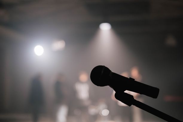 一个麦克风的特写。剪影显示了台上的麦克风。它为歌手准备好了。图片下载