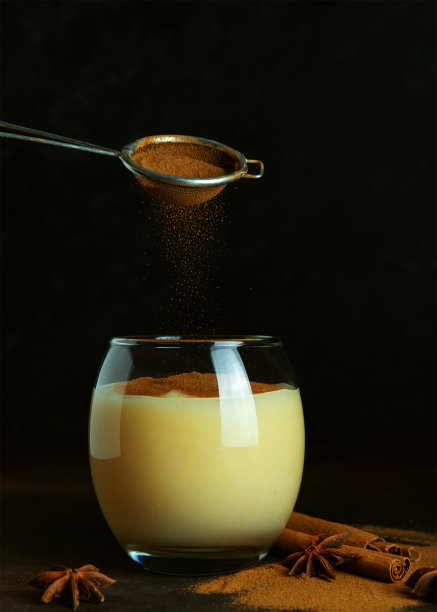 传统土耳其饮料boza和肉桂粉。美味的冬季饮料，玻璃杯，肉桂棒和八角，黑色背景。黑暗的低调照片。副本的空间。有选择性的重点。模糊的背景。图片下载