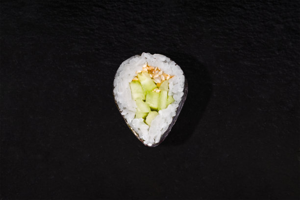 海苔卷，米饭，黄瓜和芝麻，黑色的石头背景图片下载