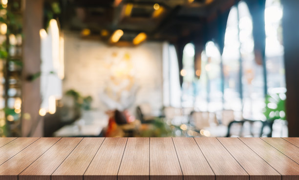 空木桌面与灯光散景模糊餐厅背景。图片下载