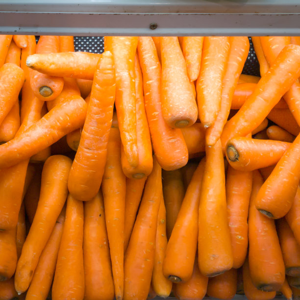 超市里成堆的新鲜胡萝卜。食品成分。图片下载