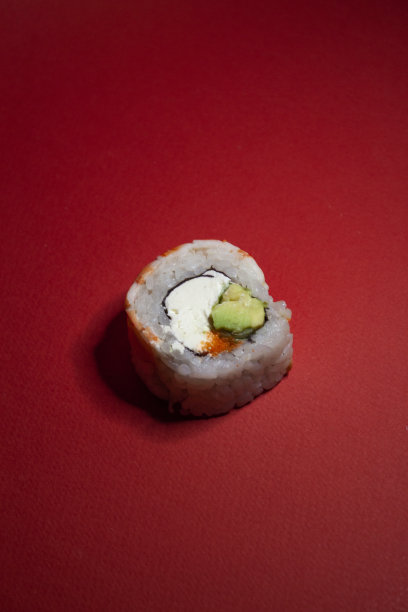 虾寿司卷，绿色牛油果和奶酪，红色背景图片下载