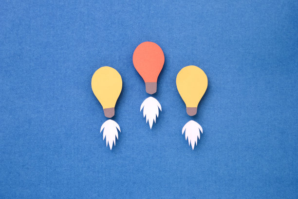 蓝色背景上彩色剪纸制作的灯泡。图片下载