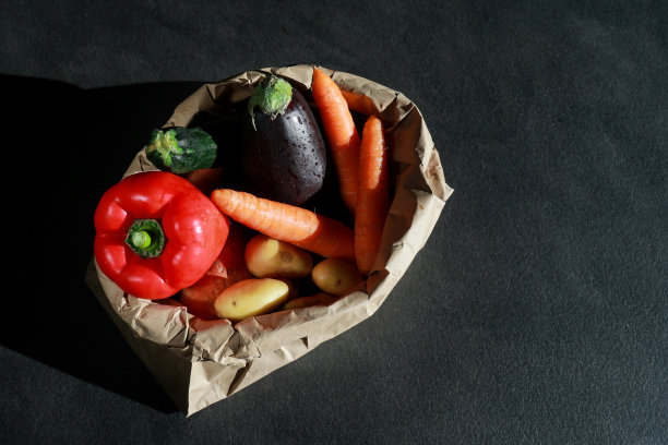 上视图的生态纸袋充满新鲜蔬菜深灰色大理石桌子与复制空间图片下载