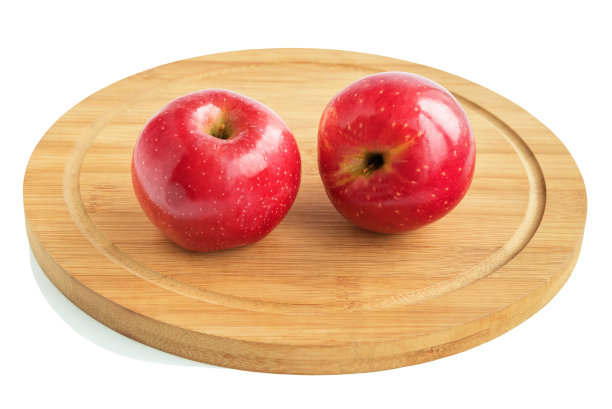 两块鲜红成熟的苹果放在厨房木板上。孤立在白色背景上。图片下载