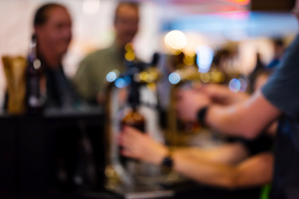 为客户将啤酒倒入棕色塑料瓶。焦点不清。高质量照片图片下载